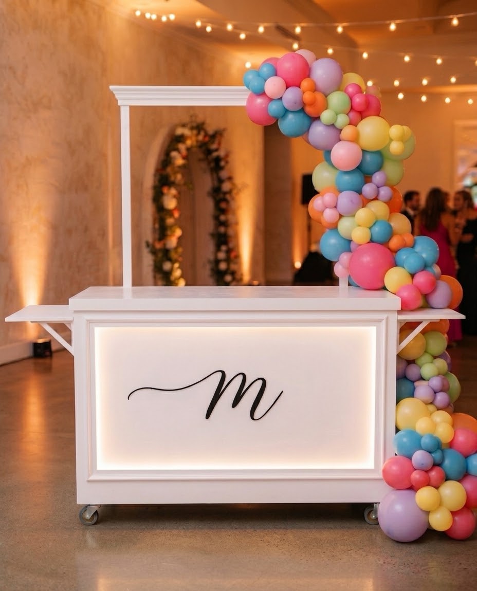 White mobile event cart with a balloon garland at a birthday party in Edmonton